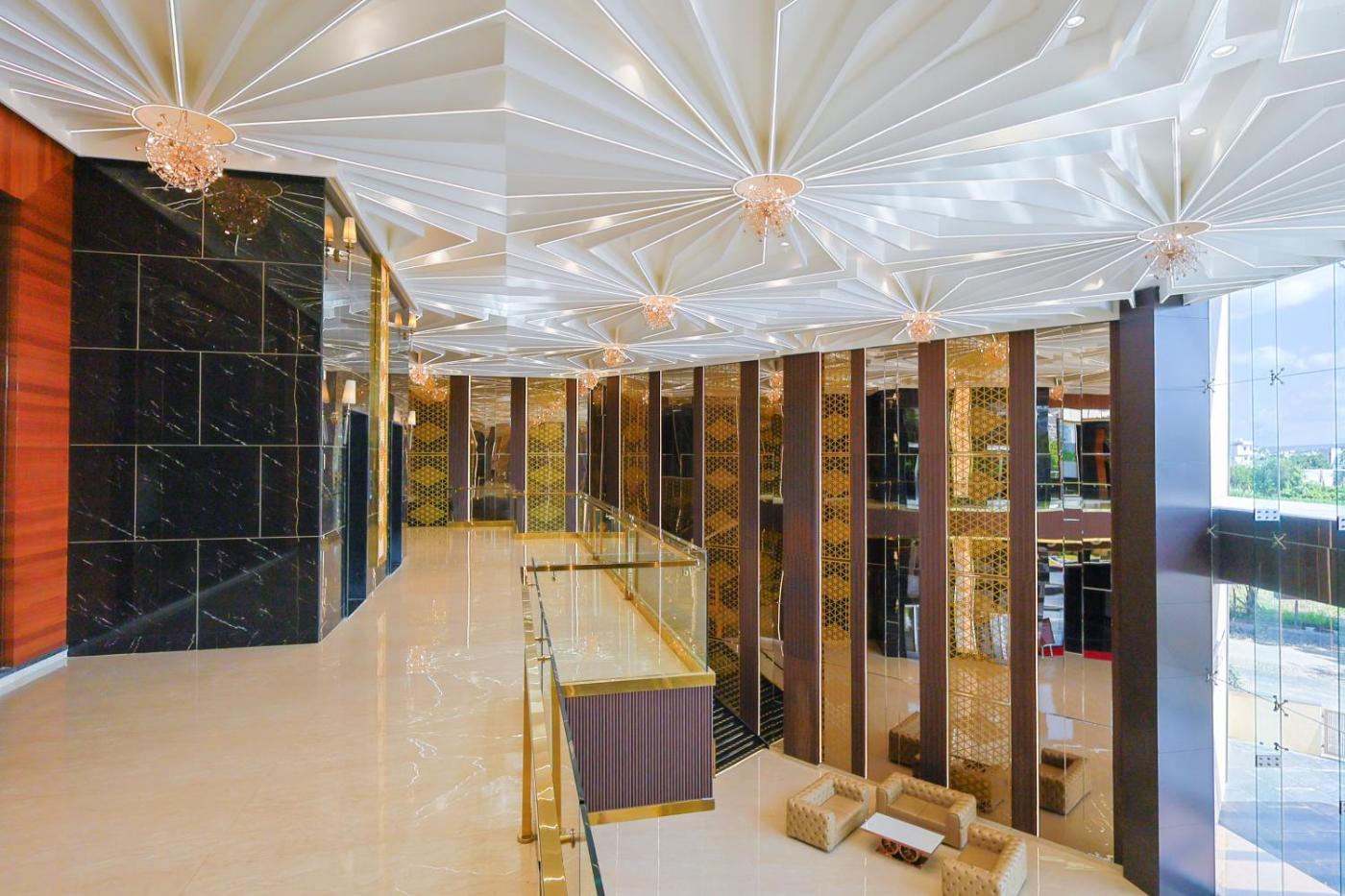 Grand double-height entrance lobby with starburst ceiling and marble pillars at Silver Star, Amravati